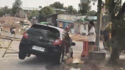 ‎Nekat Terobos Pembatas, Sebuah Mobil Berakhir Terjeblos di Proyek Jalan Muka Kuning  ‎ ‎